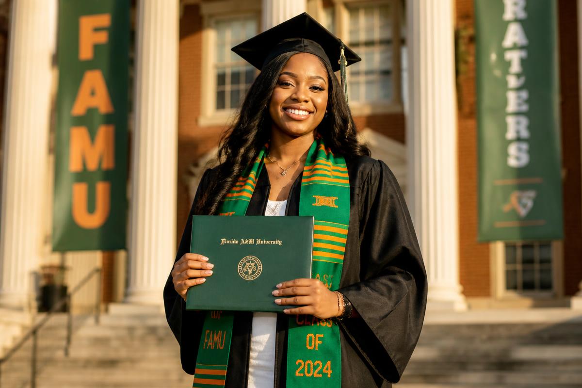 FAMU graduate celebrating achievement with diploma
